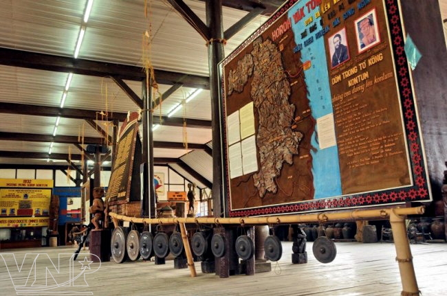 Une ensemble de gongs et une carte de Kon Tum en bois de pin exposées dans l'église