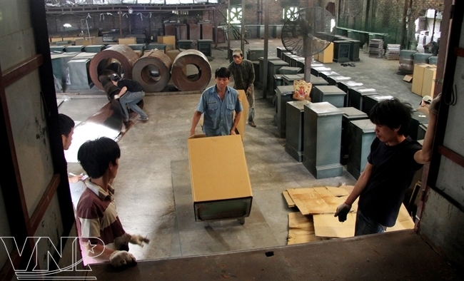 Công nhân vận chuyển két bạc trong xưởng sản xuất.