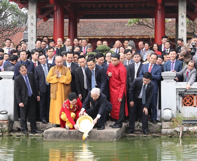 Party General Secretary and State President Nguyen Phu Trong his spouse and Overseas Vietnamese coming home for the 2019 Homeland Spring programme performed a ritual of releasing carps into Hoan Kiem Lake (the Lake of the Returned Sword) to bid farewell to the Kitchen Gods on January 26. Photo: Tri Dung/VNA