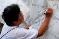Les participants au Festival écrivant des mots d’émotion sur le pont et la capitale de Hanoi.