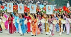 Female paraders carry the portrait of President Ho Chi Minh.