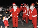 Santa Clauses distribute gifts on a street in Ho Chi Minh City.