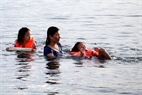 La madre siempre vigila a sus niños durante los primeros días de aprendizaje de la natación

