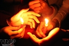 Las manos unidas para cubrir una vela. Foto: Cong Dat