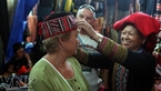外国游客试戴沙巴红瑶族人的土锦帽子。