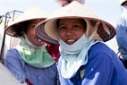 A woman with a tanned face and a radiant smile at Giao Hai Fishing Wharf.