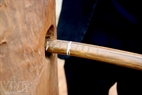 A long rattan rope is threaded through a pole on an ironwood pillar.