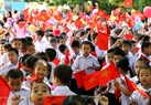 Flores multicolores y banderas en manos de los alumnos del primer grado en la ceremonia. Foto: Trong Chinh