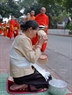 Une femme pratiquant des rites avant d’offrir du riz gluant aux bonzes.