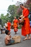 僧侣们把得到的布施品分给沿街遇见的贫困人。