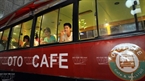 バスの窓から外を見ながら、コーヒーを飲む若者。
撮影：チャン・タイン・ザン