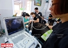 Ветеринарная медсестра из Азиатской организации по спасению животных проводит осмотр брюшной полости медведя с помощью ультразвука.