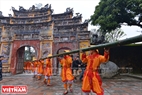 Le lourd et long «cây nêu» est porté par dix soldats via la porte de la citadelle. Photo: Thanh Hoa