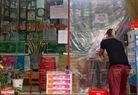 Các nhà thuốc ở Hà Nội vẫn mở cửa phục vụ người dân nhưng chủ cửa hàng lựa chọn cách bán hàng sao cho an toàn nhất. Ảnh: Tất Sơn